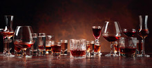 Set Of Strong Alcoholic Beverages In Glasses On A Brown Background.