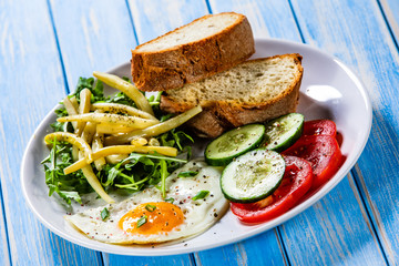 Breakfast - fried egg, toasts and vegetable salad