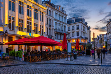 Fototapete - Old street with tables of cafe in center of Brussels, Belgium. Night cityscape of Brussels (Bruxelles). Architecture and landmarks of Brussels.