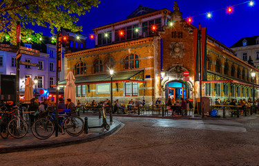 Fototapete - Old street with tables of cafe in center of Brussels, Belgium. Night cityscape of Brussels (Bruxelles). Architecture and landmarks of Brussels.