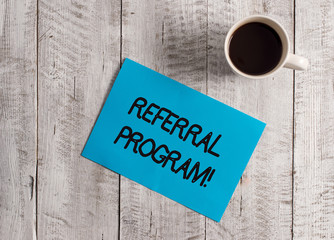 Poster - Text sign showing Referral Program. Business photo showcasing internal recruitment method employed by organizations Pastel Colour paper placed next to a cup of coffee above the wooden table