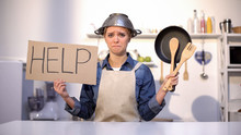 Inexperienced Housewife Asking For Help In Cooking, Wearing Pot On Head, Joke