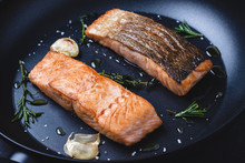Grilled Salmon Steaks In Frying Pan With Garlic And Rosemary