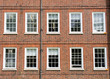 Eight windows with white sash and frame on a red brick wall Georgian British style