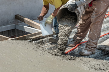 Pouring concrete at a construction site. Filling a rooftop with cement over the pipelines