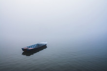 Lonely Boat On A Lake On Foggy Morning