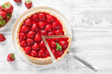 Delicious strawberry tart on white wooden background, top view