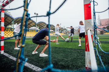 Wall Mural - Footballers Kicking football match on the Pitch. Young teen soccer game. Youth Sport.