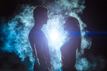 The man and woman standing in the smoke on a bright light background