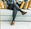 © kowitstockphoto - richness and success concept. business man sitting on a leather couch, putting his foot on the leg