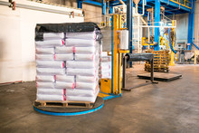Rows Or Stacks Of White Sack Bags At Large Warehouse In Modern Factory. Packaging In Factory Or Warehouse