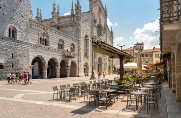 View of Duomo square with traditional Italian street cafe in the historic center of Como, Italy.