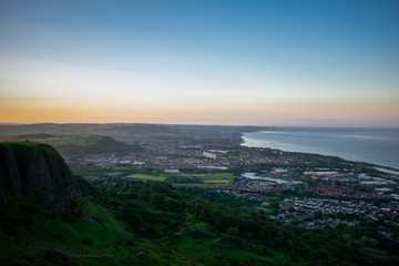 Wall Mural - Colorful sunset at Cave Hill Country Park Belfast, Northern Ireland. Aerial view on City and hills 