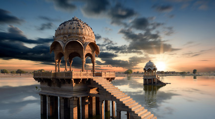 Fototapete - Gadi Sagar temple gazebo on Gadisar lake at sunset Jaisalmer, Rajasthan, India 