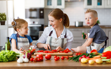 Wall Mural - mother with children preparing vegetable salad  .