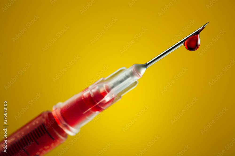 Syringe filled with blood and dripping from the needle - obrazy, fototapety, plakaty 
