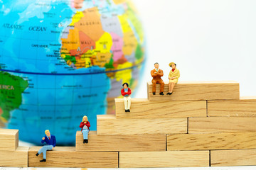 Wall Mural - Miniature people: Business people sitting on wooden box with the world.