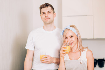 Wall Mural - Couple making fresh organic juice in kitchen together