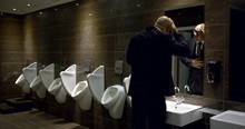 Adult Bald Businessman Is Entering In Toilet Room In Restaurant, Using Urinal