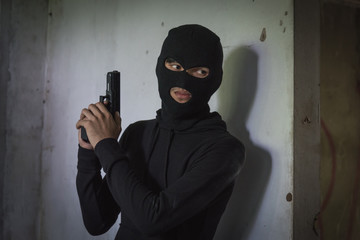 Man robber thief wear mask holding gun hiding