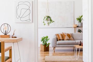 Wall Mural - The design boho interior of living room in cozy apartment with stylish coffee table, gray sofa, honey yellow pillows, desk, chair, wooden cube, plants and elegant  accessories. Cozy nice home decor. 
