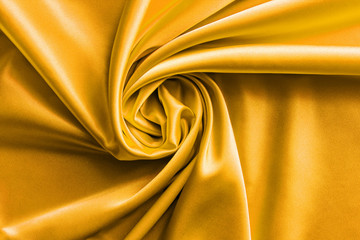 golden satin fabric with large folds, bright textile background