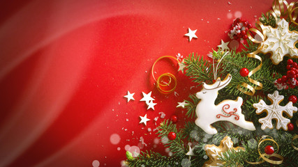 Poster - Beautiful Christmas red background with green fir branches and ginger cookies in white glaze in form of snowflakes and deer reindeer. Soft focus, top view, copy space.