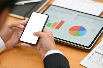 Businessman using mockup smartphone with empty screen and digital tablet analysis finance data.