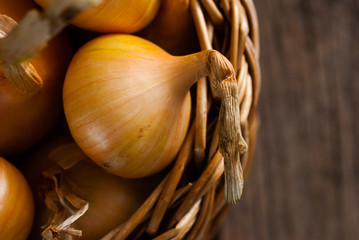 Poster - basket of onions on weathered wooden background