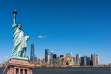 Fototapeta  - The Statue of Liberty over the Scene of New york cityscape river side which location is lower manhattan,Architecture and building with tourist concept