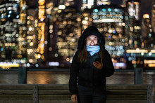 Asian Woman In Winter Suit Using Smart Mobile Phone With Smile Action Over The Photo Blurred Bokeh Of New York Cityscape Beside The East River Background, USA Downtown, Career Concept