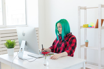 Designer, illustrator, artist and people concept - portrait of contemporary young woman with green hair using laptop and graphic tablet while working