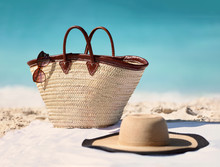 Sun Vacation Beach Winter Travel Holiday Background- Beach Bag, Fashion Hat And Sunglasses For Caribbean Relaxation. . Copy Space On Blue Ocean. Fashion Stylish Luxury Accessories.