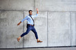 © baranq - Portrait of young businessman jumping in joy and looking at camera