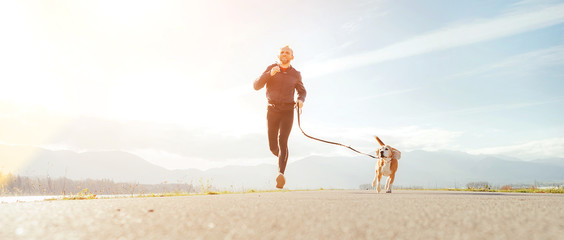 Wall Mural - Jogging man with his dog in the morning. Active healthy lifestyle concept image.