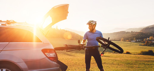 Wall Mural - Man put his bicycle in the trunk of a car opt fl