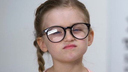 Sticker - Male ophthalmologist giving eyeglasses to small farsighted girl, health care