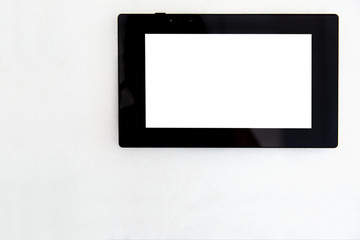 Wall Mural - tablet with black case and white blank screen front view on white wall background with copy space for text, display of smart home control device.