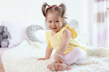 Wall Mural - Adorable little baby girl sitting on bed in room