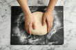 Female baker preparing bread dough at marble table, top view