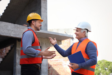 Professional engineers in safety equipment at construction site