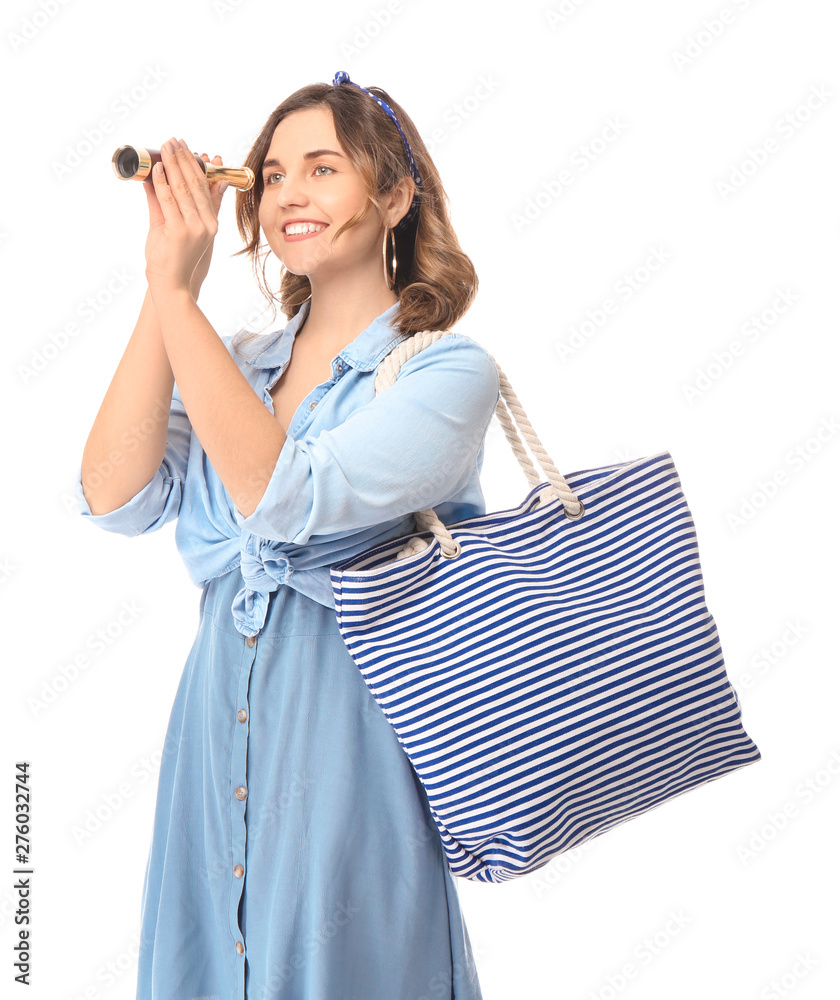 Young woman with spyglass and bag on white background