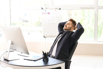 Canvas Print - Handsome businessman having break during work in office