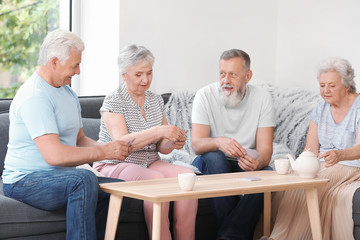 Wall Mural - Portrait of elderly people playing cards in nursing home