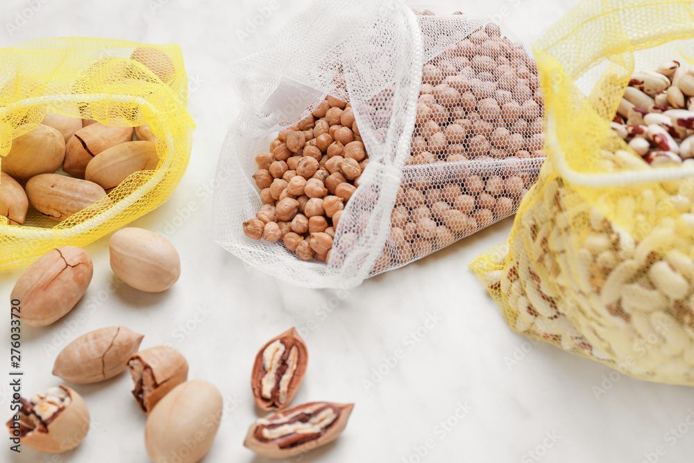 Eco bags with raw products on light background
