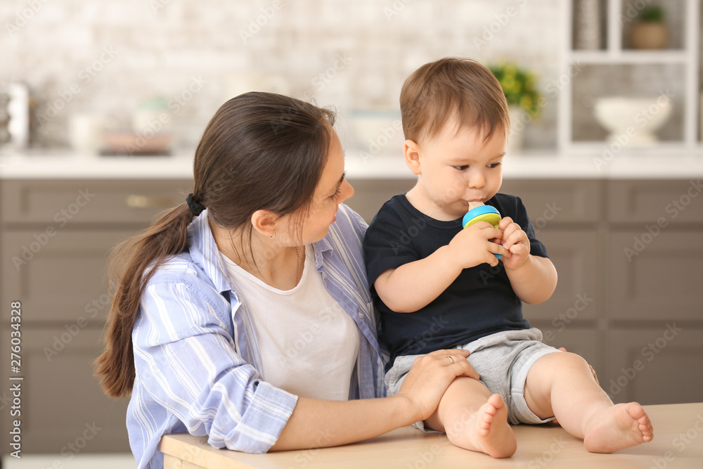 Mother and her little son with nibbler in kitchen at home