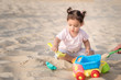© Inna - Beautiful sweet Baby girl playing on the sandy summer beach near the sea. Travel and vacation with children, Holiday concept. Summer Fun Or Best Warm Winter Family Vacations.