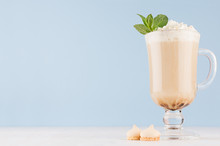 Cappuccino Coffee With Whipped Cream, Green Mint, Cookies In Transparent Glass With Handles On Soft Blue Wall And White Wood Board, Copy Space.