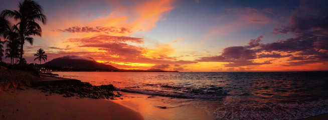 Red sunset panorama on the Caribbean beach with palm trees. Puerto Plata, Dominican Republic, Caribbean.