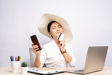 Woman wearing hat use smart phone and credit card at office isolated over background